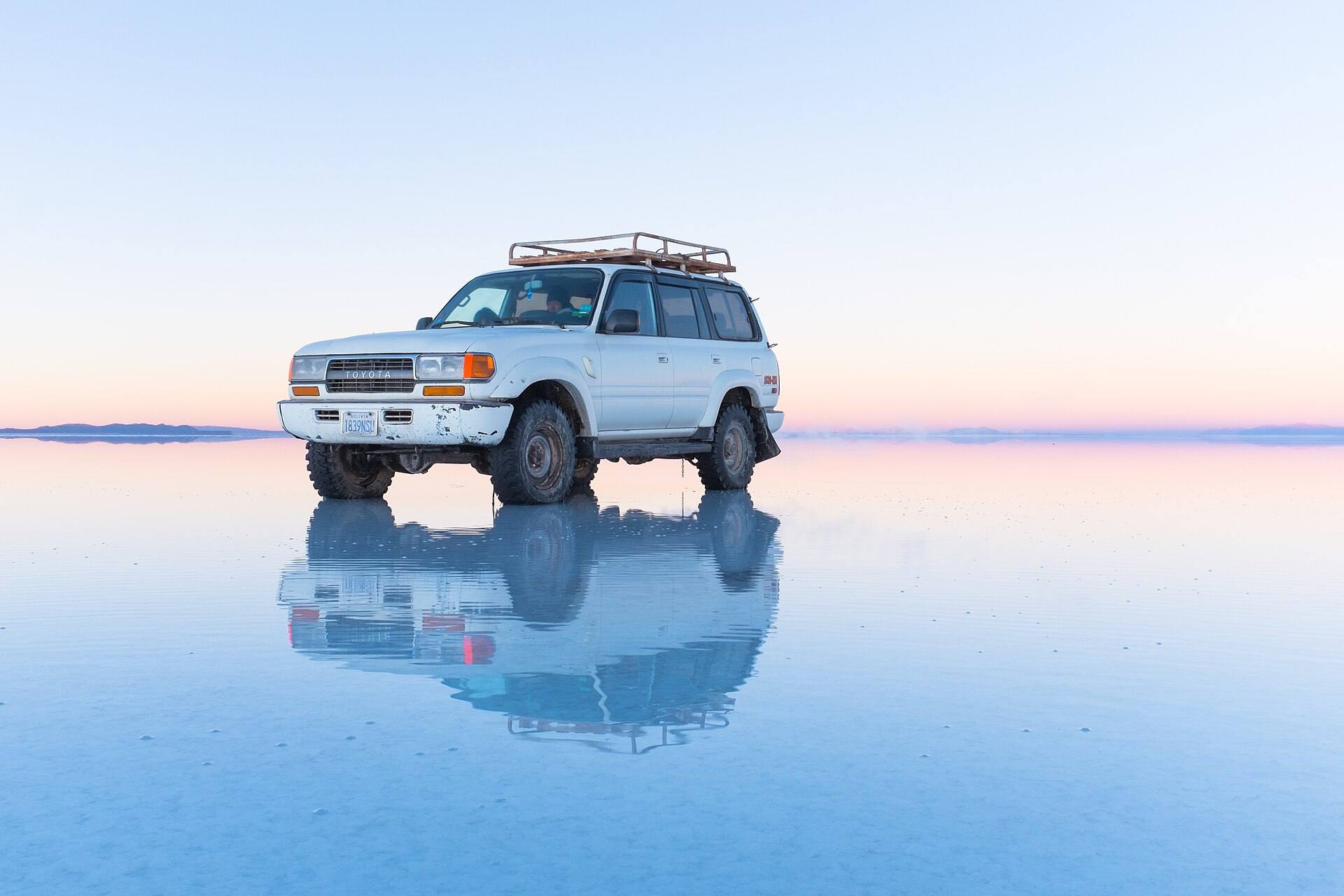 Un todoterreno blanco reflejado en agua poco profunda del Salar de Uyuni